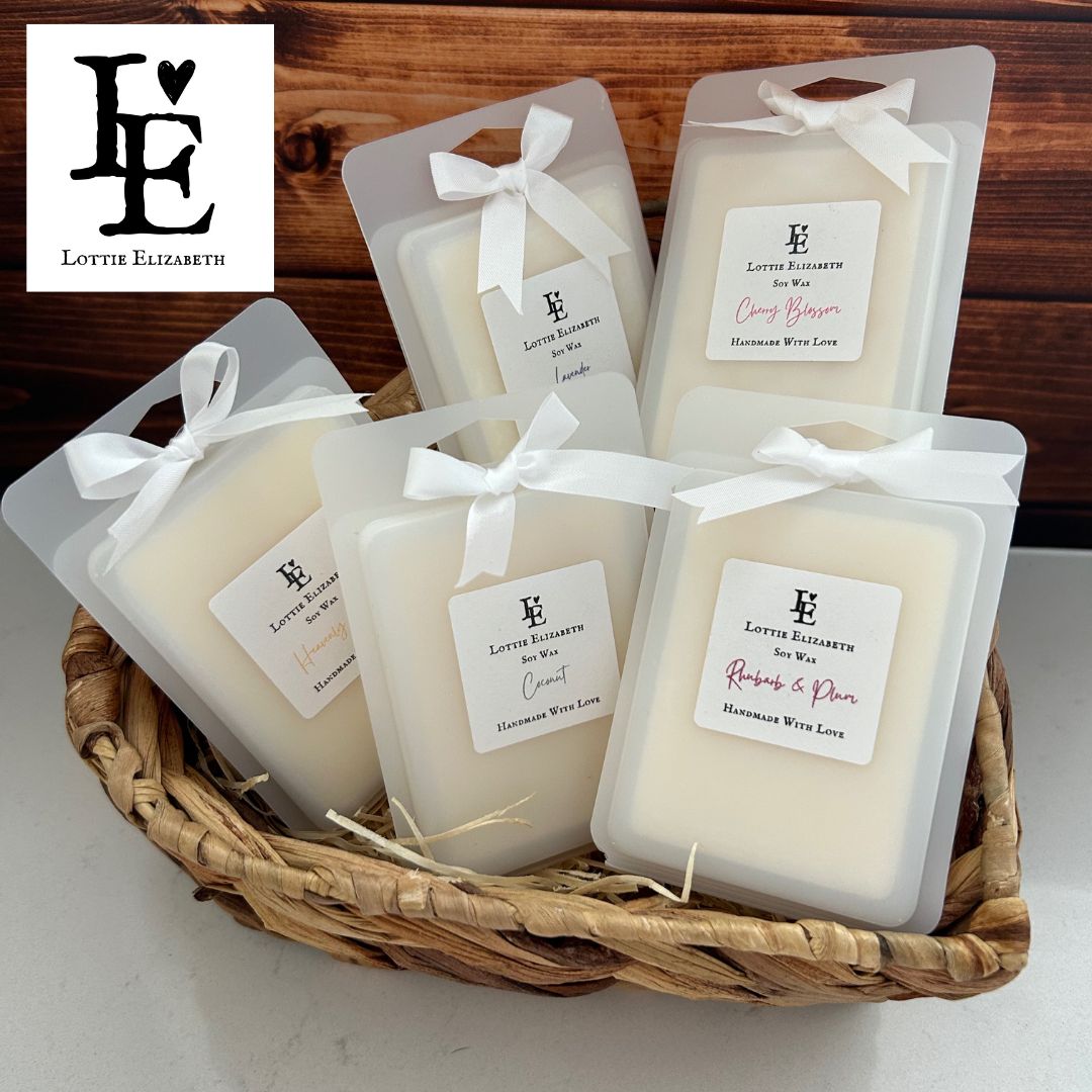 A collection of natural soy wax melts packaged in a frosted clamshell. The melts are arranged in neat rows. The packaging is sleek and translucent, providing a glimpse of the scented wax within. There are 6 cubes per wax melt.